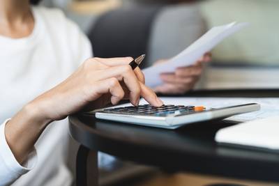 Geschäftsfrauen verwenden Taschenrechner, um das Unternehmensbudget und die Einkommensberichte auf dem Schreibtisch im Büro zu berechnen.