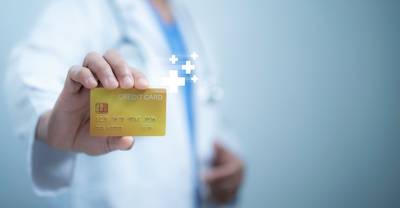 Ein Arzt in einem weißen Kittel, der eine Kreditkarte trägt, die Gesundheitsversorgung und Finanztransaktionen, Krankenversicherungszahlungen, Gesundheitsfinanzierung und die Kosten für medizinische Dienstleistungskonzepte darstellt
